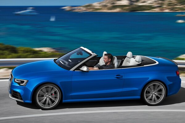 Audi-Auto, in dem ein Mann sitzt und versucht, irgendwo vor dem Hintergrund des Meeres zu gehen
