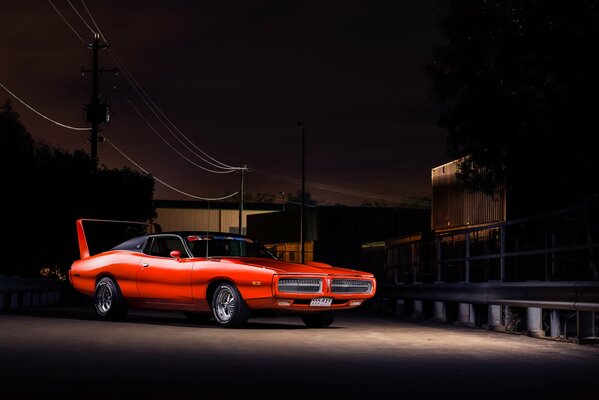 Dodge Charger rojo sobre fondo oscuro