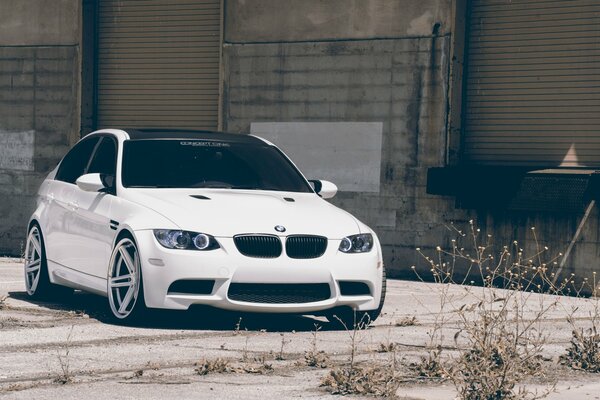 White BMW stomt in the parking lot next to the building