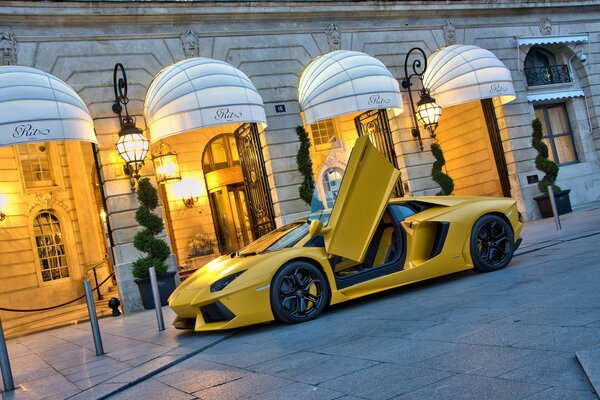 Gelber lamborghini aventador lp700-4 in der Nähe des Gebäudes