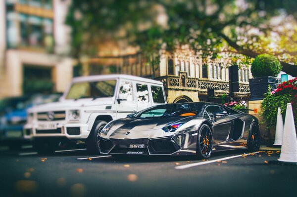 Two expensive cars are parked in the parking lot