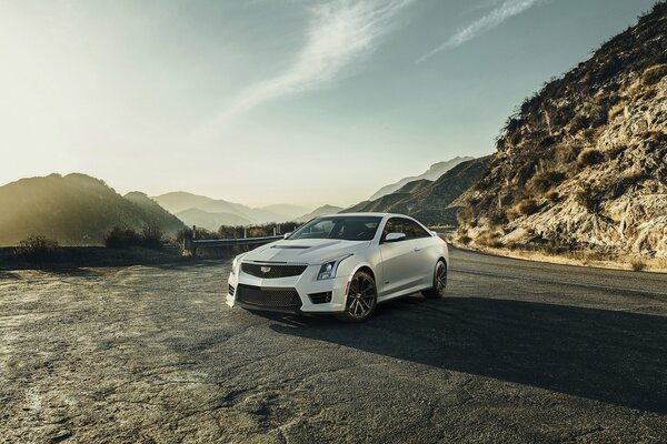 Cadillac coupé bianco sullo sfondo di catene montuose