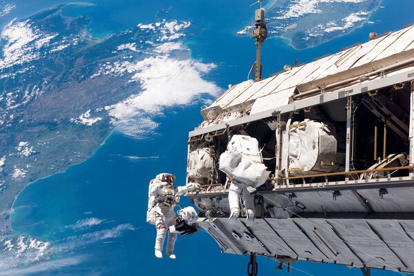 The work of Astronauts in weightlessness against the background of the Earth