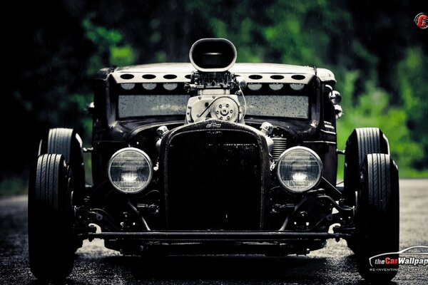 An old car driving on the road in rainy weather