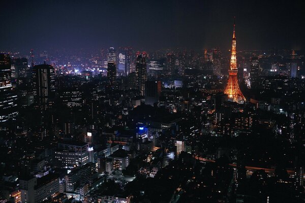 Ciudad nocturna en luces con una torre luminosa