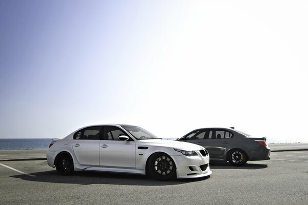 Two bmw m5 e60 in the parking lot by the sea