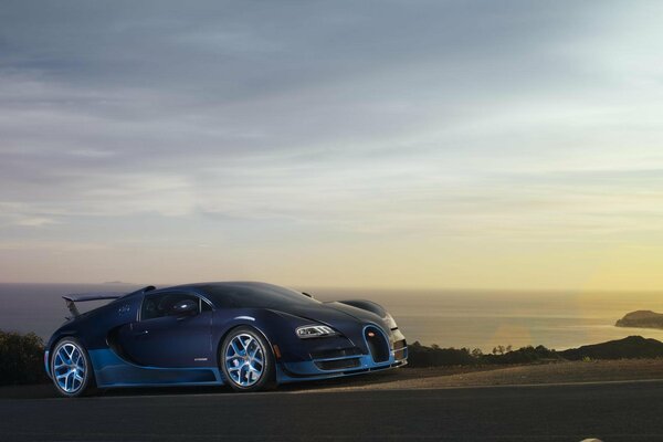 Blue bugatti on the background of the sea at sunset