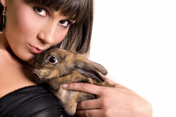 Chica con un conejo sobre un fondo blanco