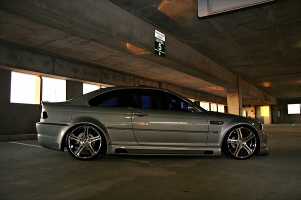 Silver BMW with big wheels in the parking lot