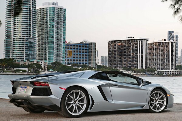 Lamborghini supercar, Lamborghini on the riverbank, Lamborghini aventador against the backdrop of the urban landscape, lamborghini roadster