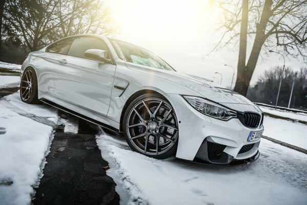 Weißer BMW auf verschneiter Straße