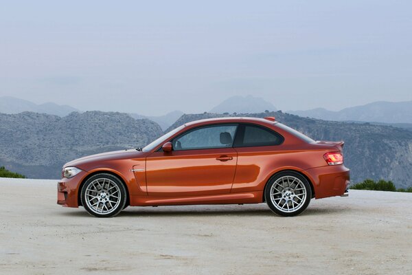 Orange BMW Auto auf dem Hintergrund der Berge