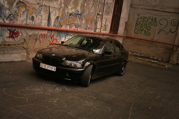 BMW E46 na tle ściany z graffiti