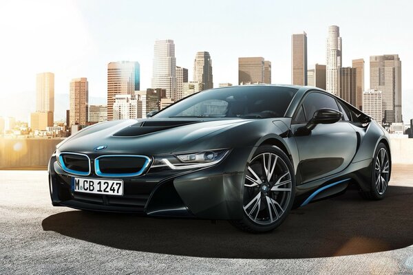 A black BMW standing against the backdrop of a huge city