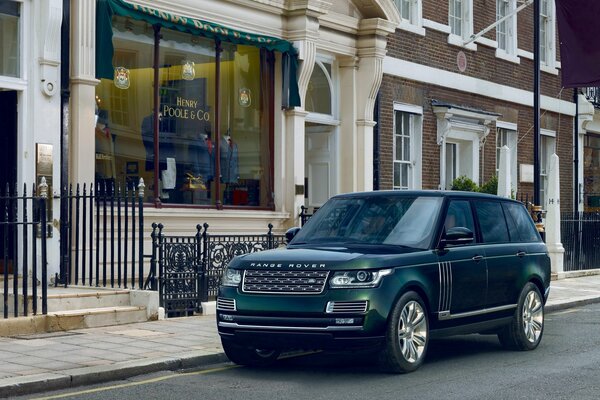 Land Rover in dunkler Smaragdfarbe auf einer Stadtlandschaft