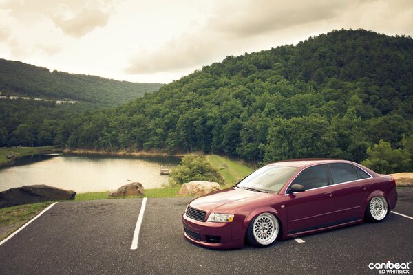 Roter Audi a4 np Hintergrund von See und Bergen