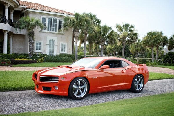 Red sports car on the background of a two-storey villa