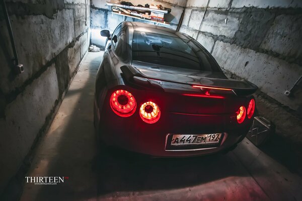 Nissan with headlights on in the garage
