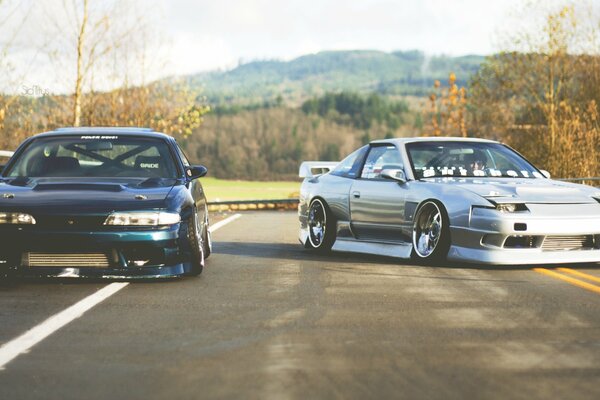 Two old racing cars on the road