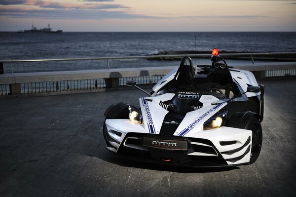 White sports car by the sea in the evening