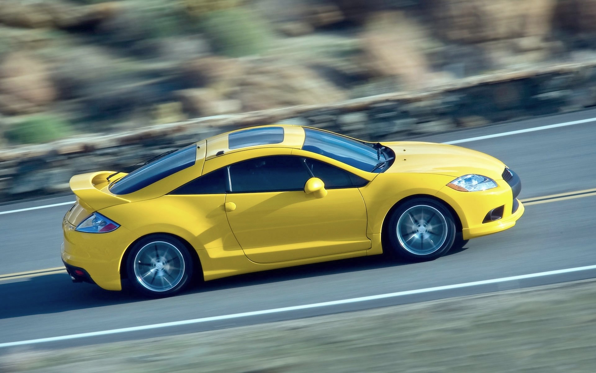 mitsubishi éclipse auto jaune vue latérale en mouvement