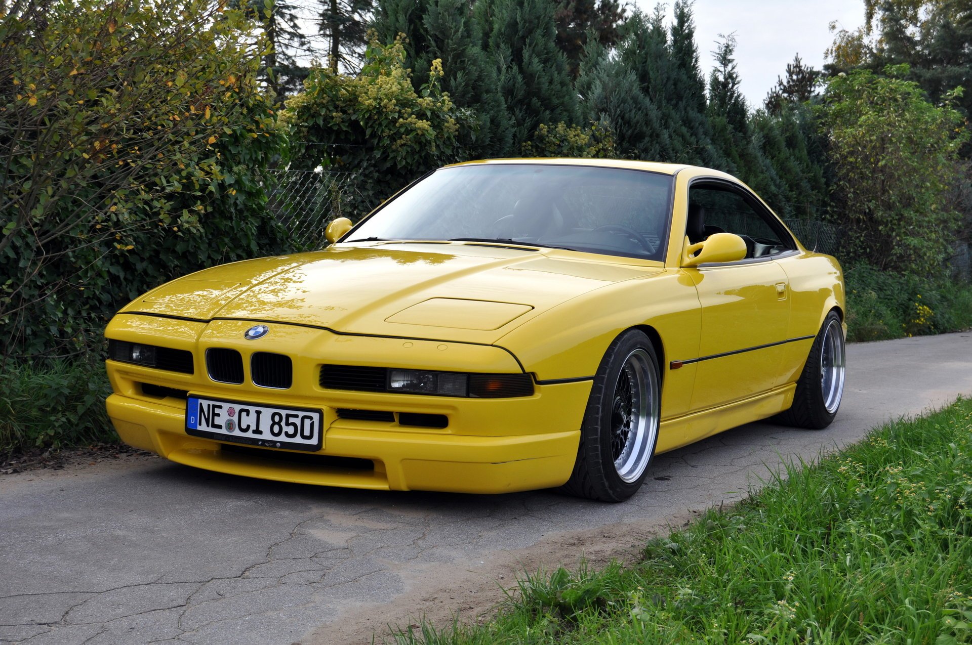 bmw 850 e31 bmw bmw coupe samochód sportowy żółty styl design hightech techno niemcy bawaria auto żółte auto samochód samochód transport trawa żywopłot zieleń liście samochody pojazd