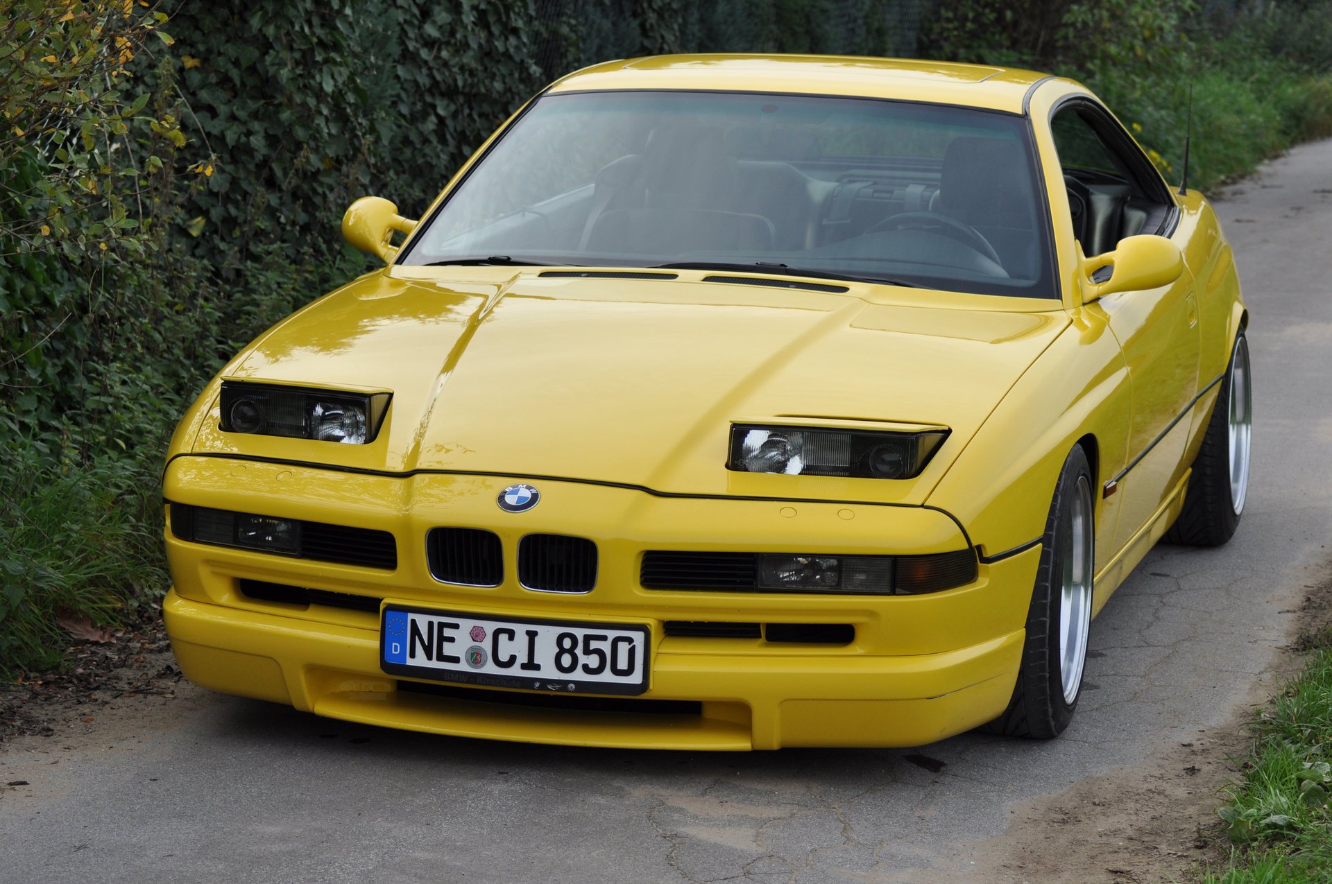 bmw 850 ci e31 bmw bmw coupé auto sportiva giallo stile design high-tech techno germania baviera auto giallo auto auto auto trasporto erba siepe vista frontale verde fogliame automobili veicoli