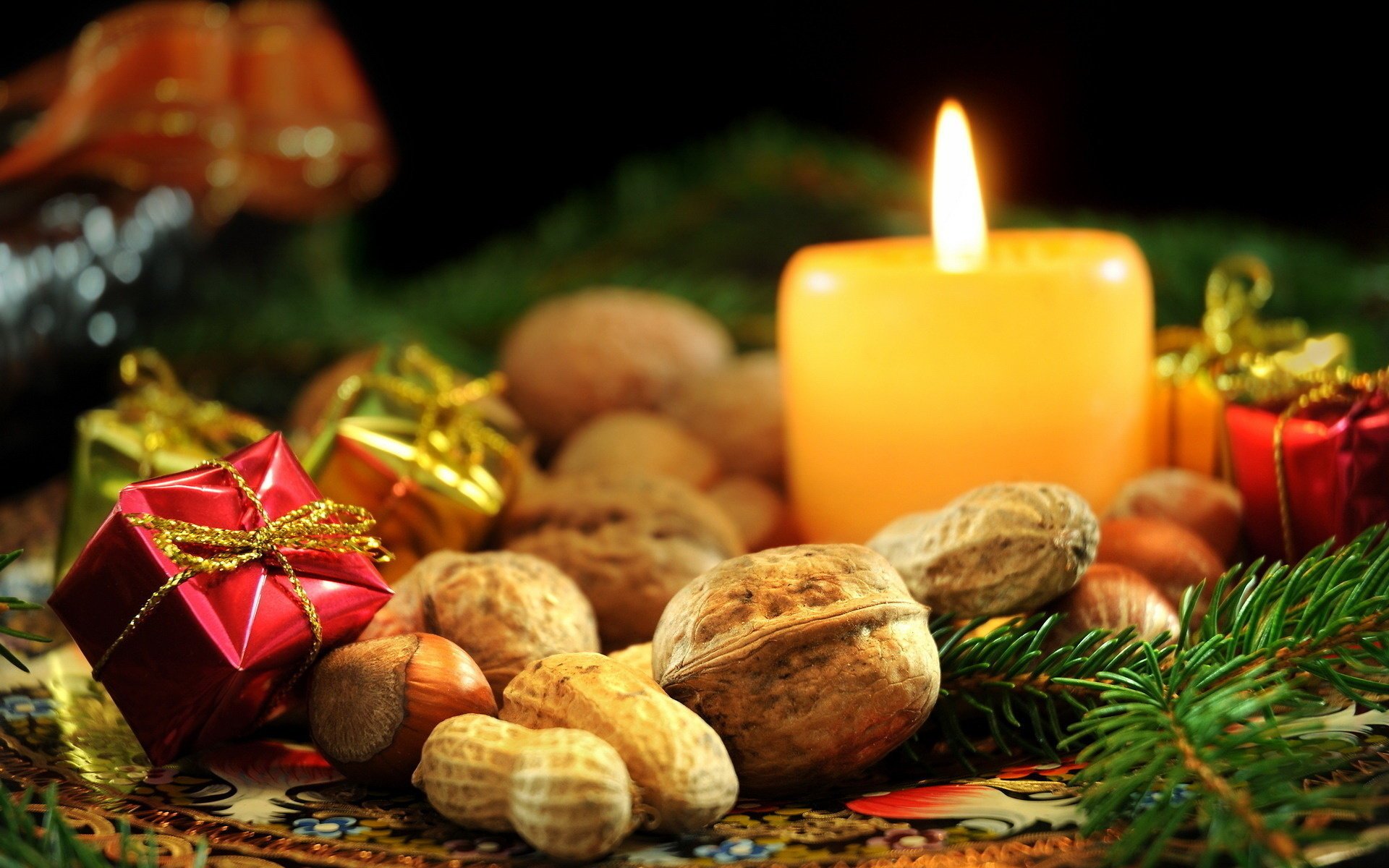 anacardos año nuevo enfoque vacaciones vela nueces regalos avellanas nueces agujas de pino rama abeto fuego macro decoración llama