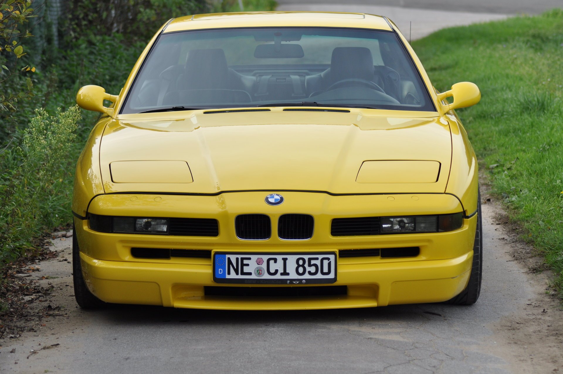 bmw 850 e31 bmw bmw coupé voiture de sport jaune style design high-tech techno allemagne bavière auto voiture jaune voiture véhicule transport herbe haie vue de face verdure feuillage voitures véhicules