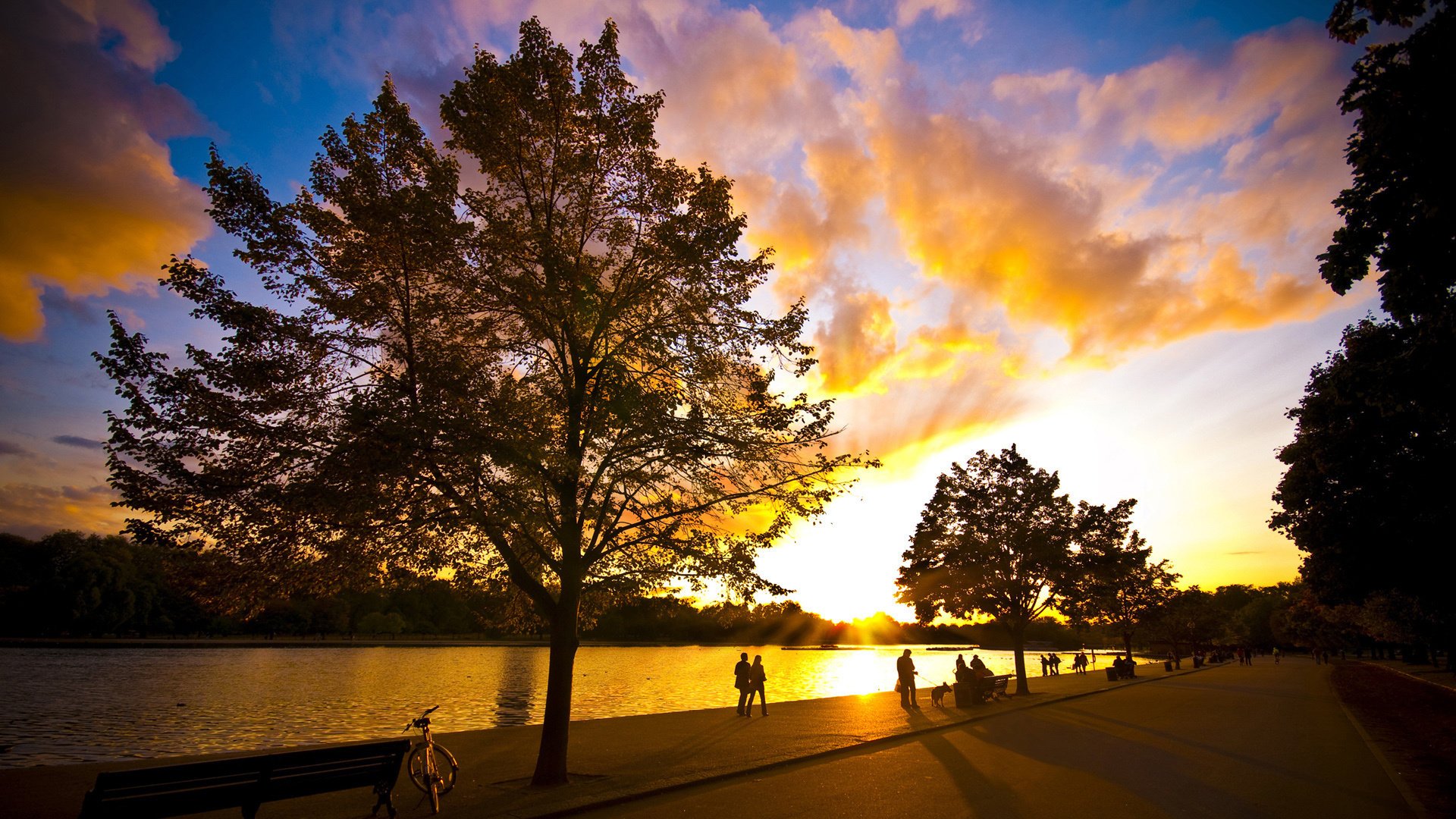 red ble sunset trees rivers sky nature embankment people city evening passers-by rest benches square river surface cloud