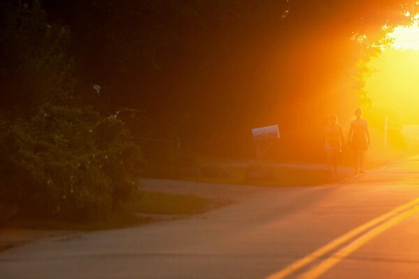 Sagoma di persone che camminano lungo il lato della strada