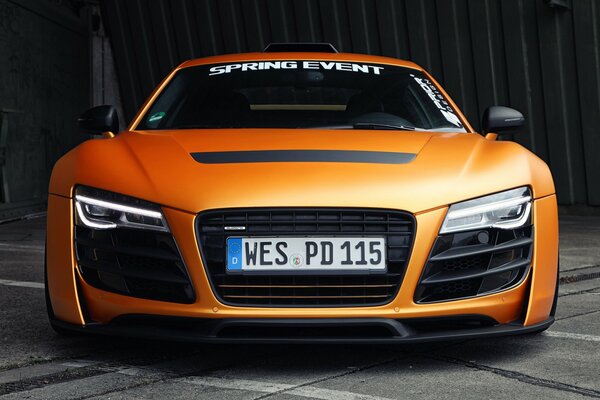 Voiture orange de marque audi avec vue sur les phares avant