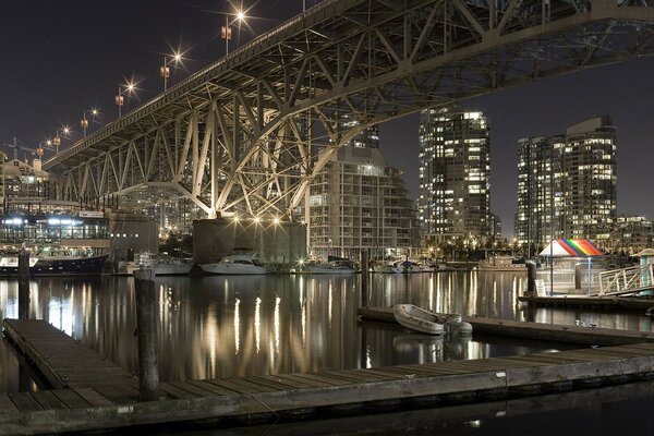 Pont sur la rivière de nuit. Lumières de la ville