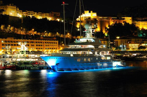 Weiße Yacht vor dem Hintergrund des abendlichen Monte Carlo