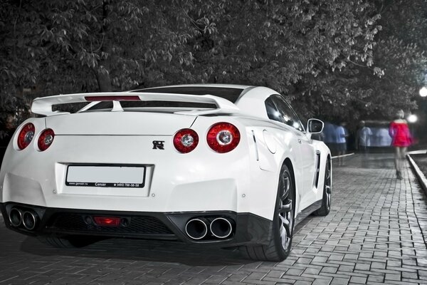 A white sports car standing on the sidewalk