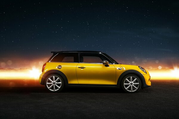 Mini cooper s amarillo contra el cielo estrellado