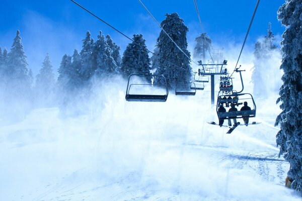 Snowboarders lift to the snow-covered mountain