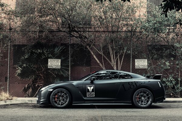 Black matte nissan by the trees