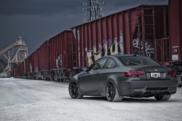 Black car on the background of railway transports