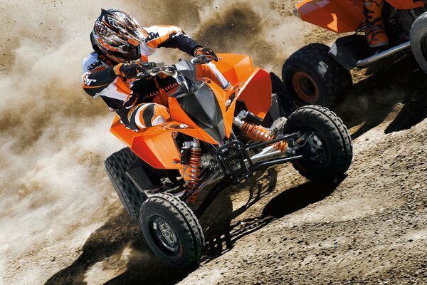 Mann fährt mit Quad auf Sand