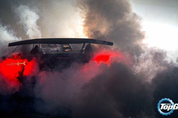 Lamborghini in the middle of smoke on the road