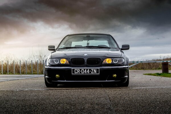 Bmw e46 auf grauem Asphalt mit Tuning-Scheinwerfern