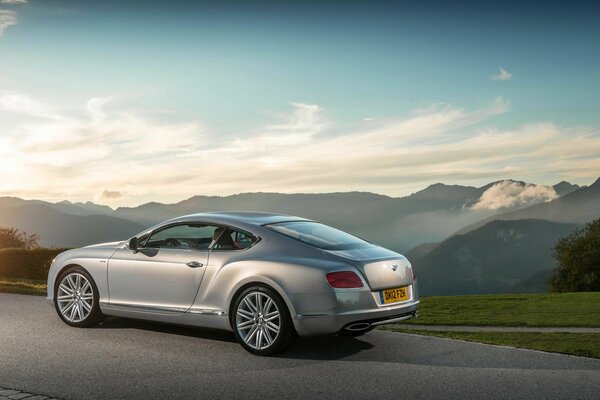 Grey bentley with cast wheels on the background of mountains