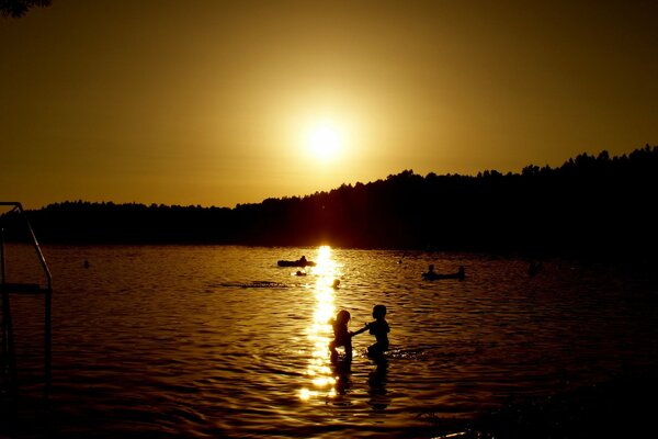 Menschen baden vor dem Hintergrund des Sonnenuntergangs