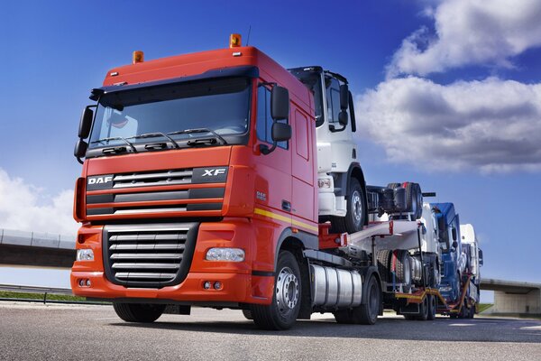 Camion transportant des camions sous un ciel dégagé