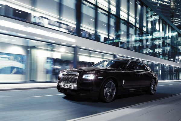 Negro Rolls Royce ghost v-características en el tráfico en la ciudad de la noche