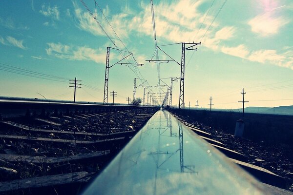 Reflexión de los postes en en el carril metálico brillante