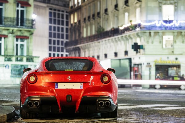 L auto rossa Ferrari si trova sullo sfondo degli edifici