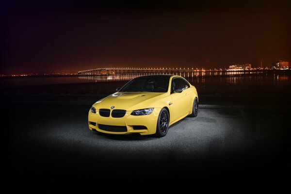 BMW jaune sur fond de ville de nuit