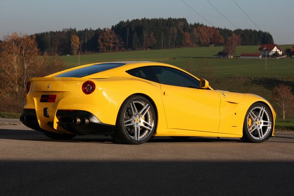 Bright and beautiful yellow racing car on the background of picturesque nature